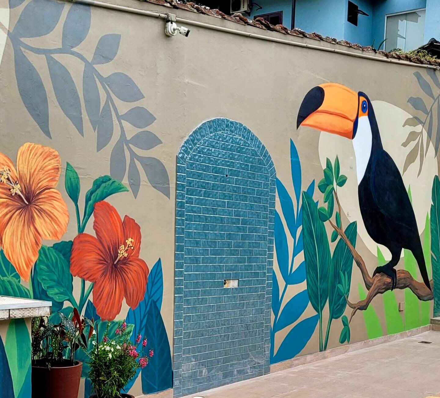 O mural do tucano e os nichos em arco revestidos de pastilha ao longo do muro da piscina.